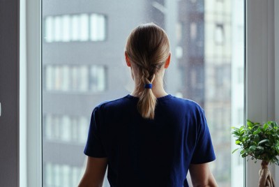 γυναίκα μπροστά σε παράθυρο αντιμετωπίζει ενήλικες ψυχολογικές δυσκολίες