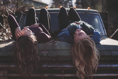 δύο γυναίκες ξαπλωμένες στο καπό ενός αυτοκινήτου