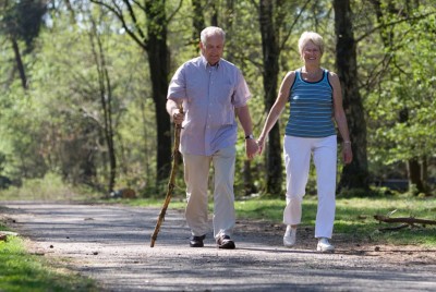 ηλικιωμένο ζευγάρι περπατάει σε πάρκο