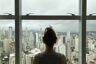 γυναίκα κατά τη διάρκεια πανδημίας κοιτάζει έξω από το παράθυρό της