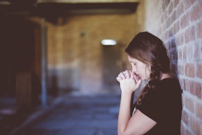 κορίτσι που στηρίζεται σε ένα τοίχο από τούβλα έχει λανθασμένη αντίληψη για το άγχος