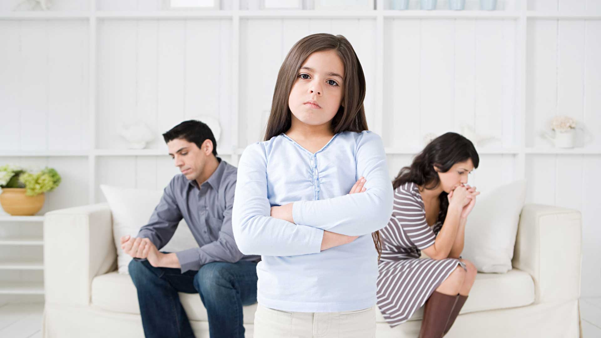 κορίτσι που στέκεται θυμωμένο μπροστά από τους γονείς που κάθονται σε καναπέ