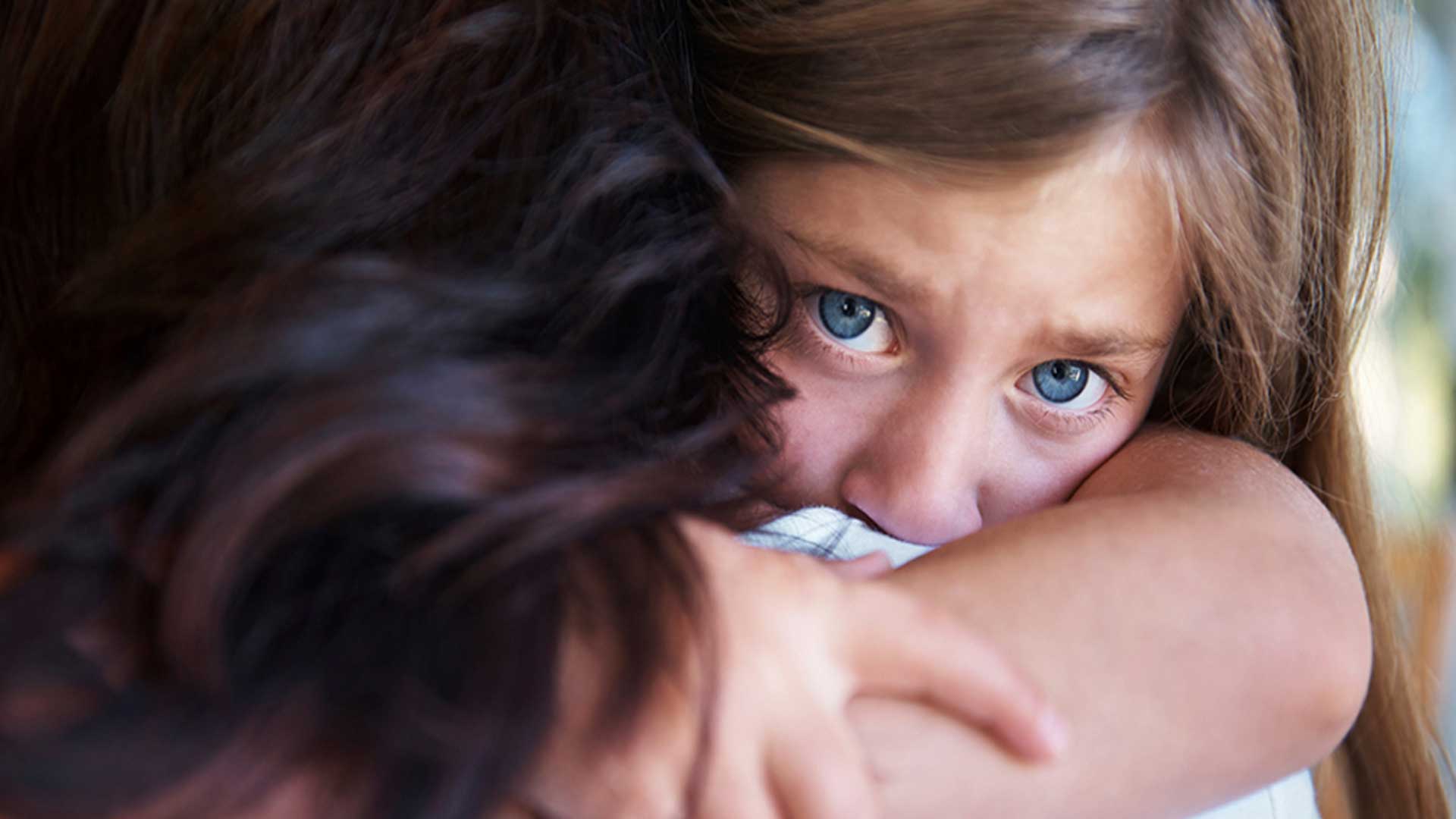 κοριτσάκι με μπλε μάτια αγκαλιάζει τη μητέρα του