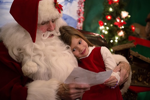 Άγιος Βασίλης που διαβάζει παραμύθι σε ένα κοριτσάκι