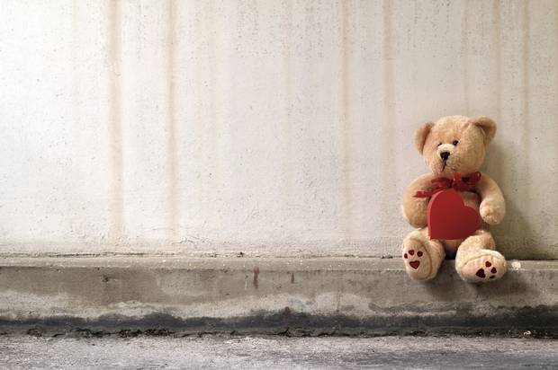 λούτρινο αρκουδάκι κρατάει μια καρδιά στην άκρη του δρόμου
