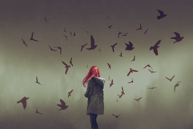 γυναίκα με κόκκινα μαλλιά περιτριγυρίζεται από πουλιά