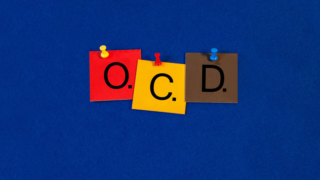 γράμματα της αγγλικής αλφάβητου καρφιτσωμένα σε μπλε πίνακα σχηματίζουν το OCD την Ιδεοψυχαναγκαστική Διαταραχή τον δαίμονα της τελειότητας