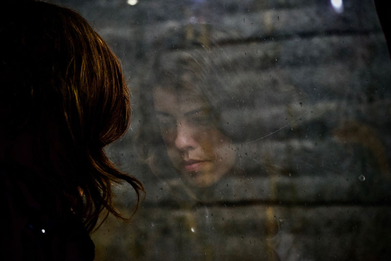 γυναίκα κοιτάζει από το παράθυρο προς ένα τοίχο έχοντας κατάθλιψη και όχι λύπη