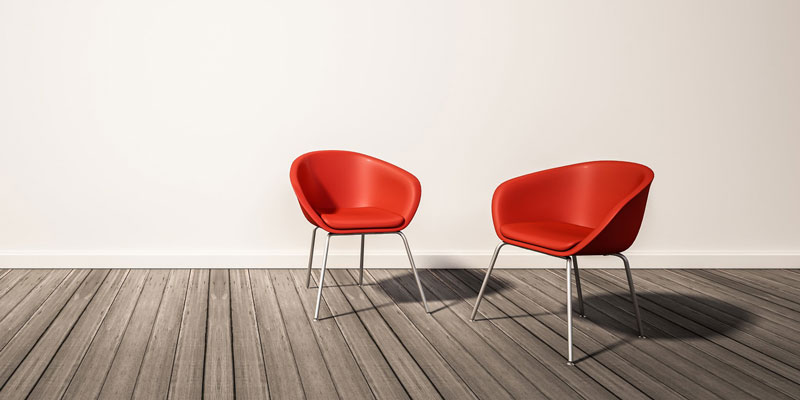δύο κόκκινες καρέκλες πάνω σε ένα ξύλινο πάτωμα