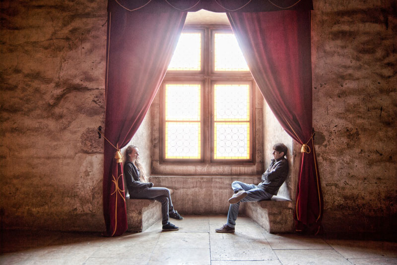 δύο άνθρωποι κάθονται αντικροιστά μπροστά από ένα παράθυρο