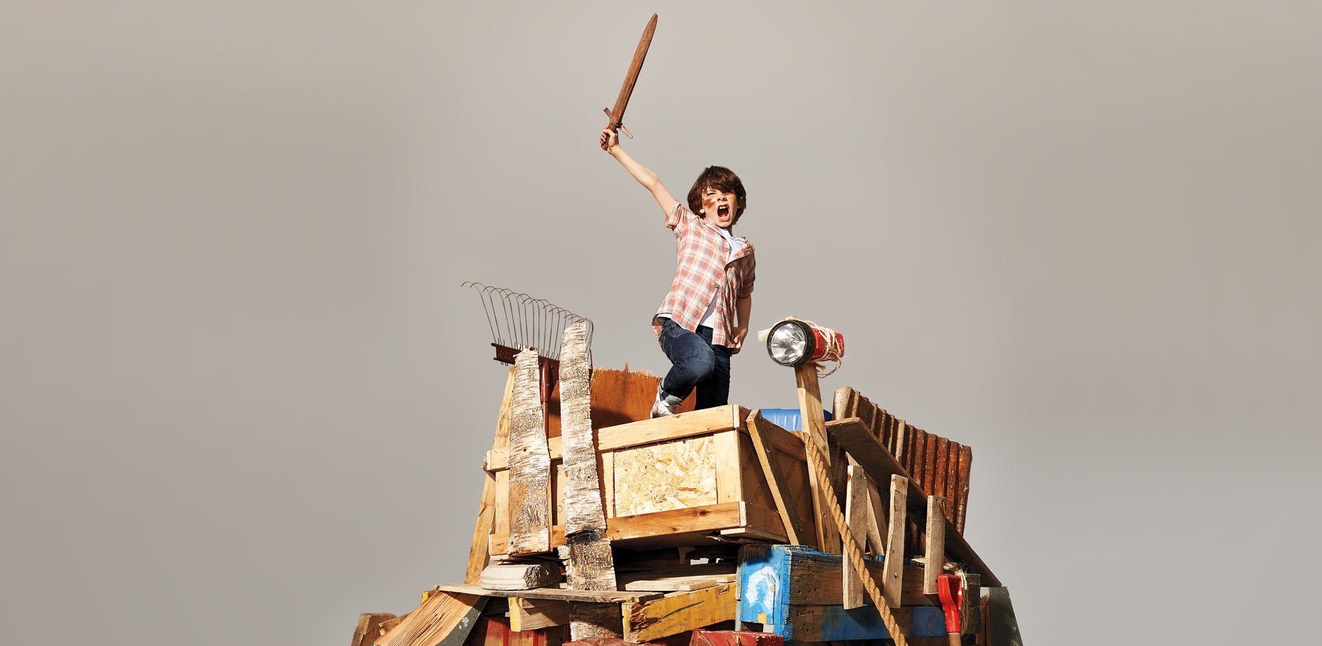 παιδί κρατάει ξύλινο σπαθί σε αυτοσχέδιο οχυρό και απεικονίζει την παρακμή του παιχνιδιού και την άνοδο των ψυχικών διαταραχών στα παιδιά
