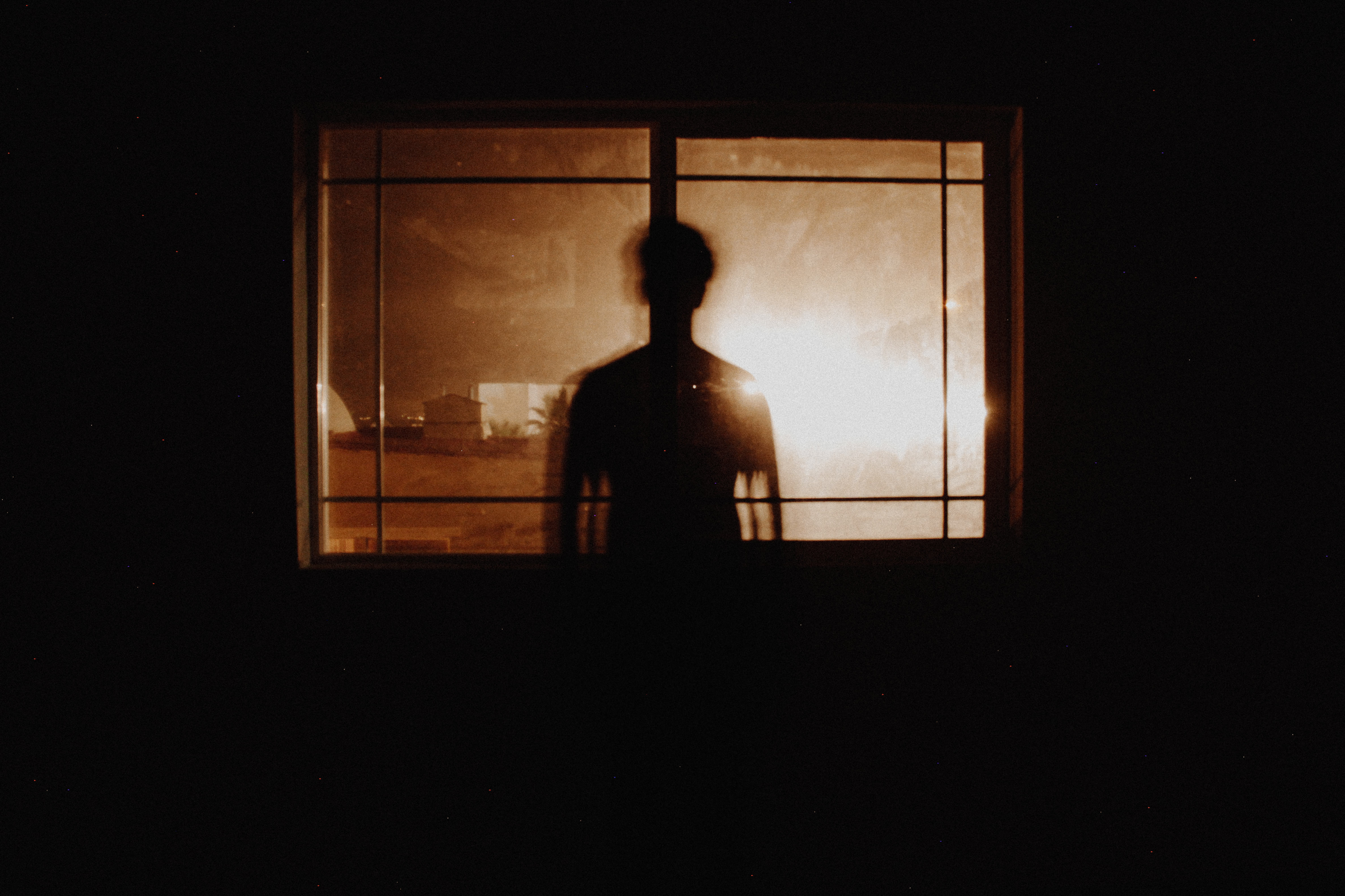 σιλουέτα ατόμου πίσω από ένα παράθυρο σε ένα σκοτεινό δωμάτιο έχει σημάδια συναισθηματικής κακοποίησης που πολλοί δεν αναγνωρίζουν