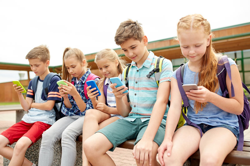 παιδιά διαφόρων ηλικιών ασχολούνται με Smartphones