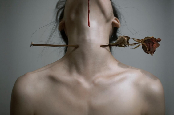 γυναίκα τρυπημένη στο λαιμό από τριαντάφυλλο δείχνει την ηθική παρενόχληση που είναι μια νέα μορφή βίας