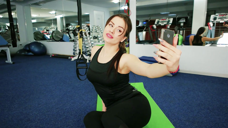γυναίκα που τραβάει selfie στο γυμναστήριο χαμογελώντας