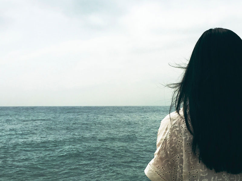 γυναίκα κοιτάζει προς τη θάλασσα και απεικονίζει της ψυχοθεραπείας της μέσα από 10 σκίτσα