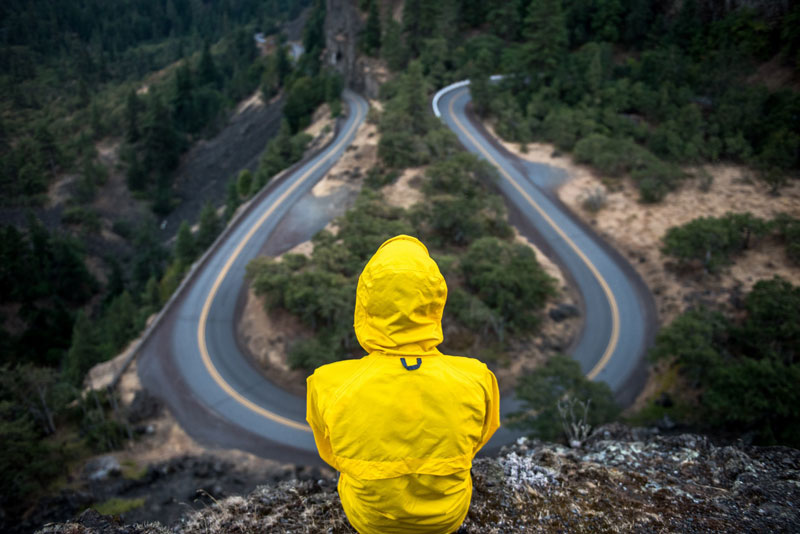 άνθρωπος που φορά κίτρινο αδιάβροχο κάθεται κοιτώντας από ψηλά το δρόμο