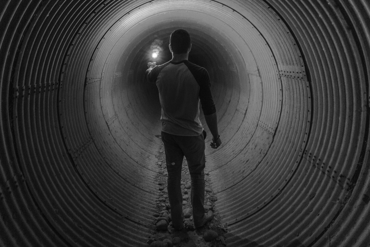 άνδρας μοναχικός σε ένα τούνελ με ένα φως στο χέρι
