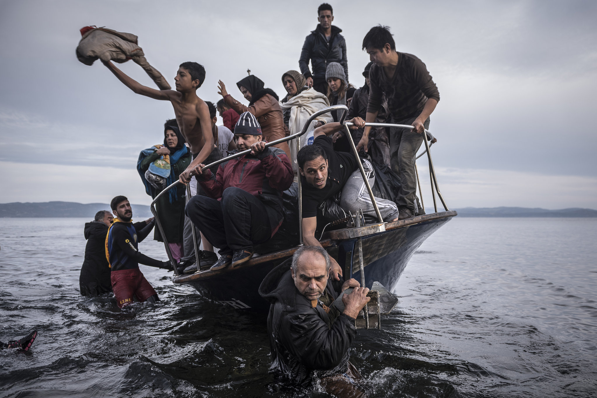άντρας φέρνει στη στεριά βάρκα με πρόσφυγες